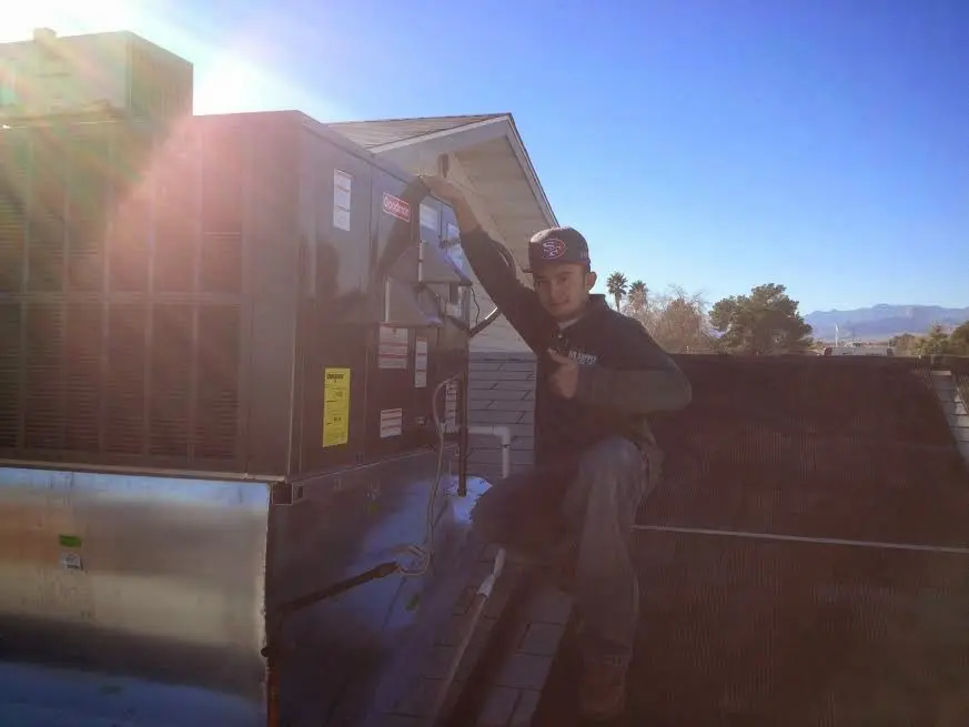 HVAC technician performing AC Tune-Up on a rooftop unit in Pooler